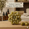 Flower shaped organic moringa soap with three green olives on a wooden table.