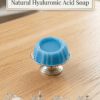 Round textured hyaluronic acid soap on stand with coconut base and alpha arbutin icons below