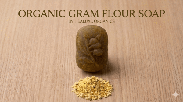 Single oval organic gram flour soap with a leaf imprint and a small pile of besan powder below it.